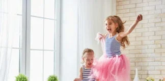 2 girls jumping on bed